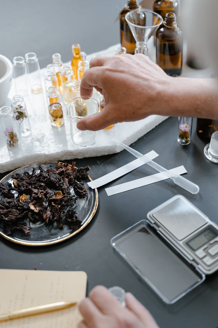 Experimenting with natural oils and herbs to blend unique aromas in a modern laboratory setting.
